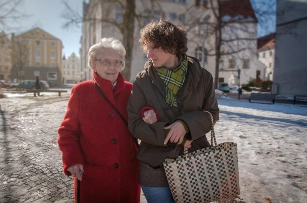 Eine ältere Frau wird von einer anderen Frau beim Einkaufen begleitet Eine ältere Frau wird von einer anderen Frau beim Einkaufen begleitet